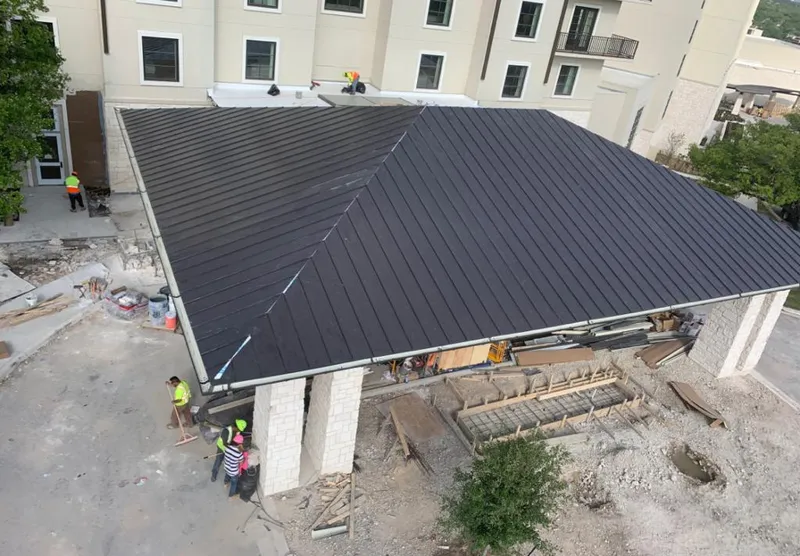 Metal roofing installation team working on a commercial building in Pensacola Station